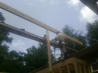 Carpenter setting a ridge beam over a new addition frame — Ice Dam Removal by Roofing Brothers in Armbrust