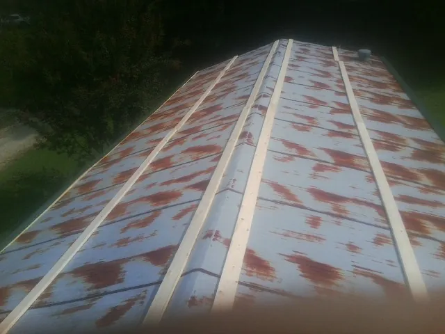 Rusted metal roof panels with new wood purlins before replacement — Storm Damage Roof Repair in Armbrust by Roofing Brothers